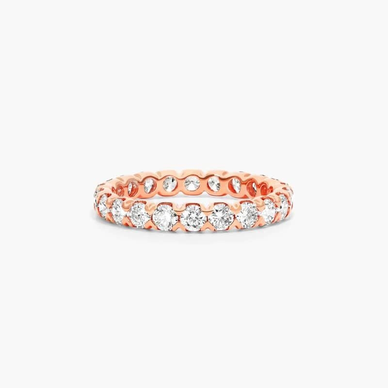 This sculptural fishtail diamond eternity ring features scalloped settings and chevron shaped prongs that rise and secure in place a row of gleaming diamonds to create a unique and luxurious design. *Number of diamonds and carat total weight will vary depending on ring size.
