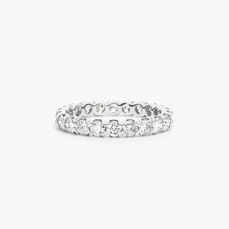 This sculptural fishtail diamond eternity ring features scalloped settings and chevron shaped prongs that rise and secure in place a row of gleaming diamonds to create a unique and luxurious design. *Number of diamonds and carat total weight will vary depending on ring size.
