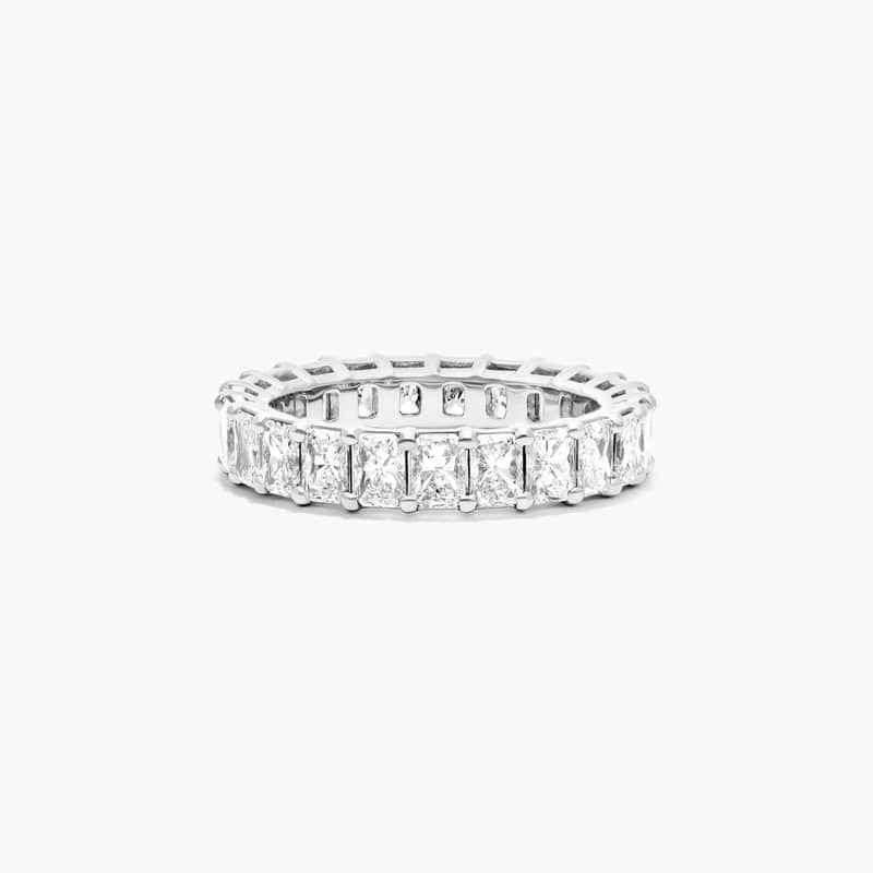 This timeless eternity ring features the boldness and intense sparkle of radiant cut diamonds. A classic, tailored shared prongs setting allows the maximum amount of the diamonds surface to show. *Number of diamonds and carat total weight will vary depending on ring size.