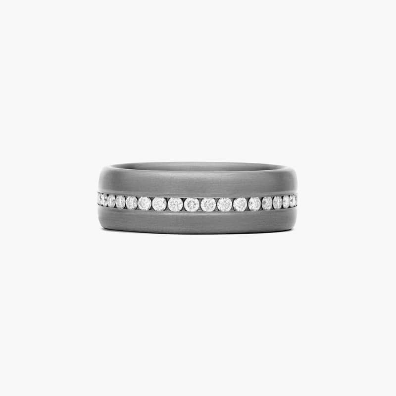 The smooth edges of the tantalum ring are perfectly complemented by an elegant channel set diamond row.