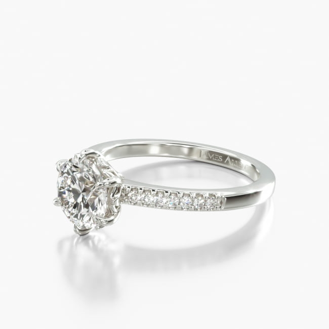 A modified French cut band adorned with round brilliant diamonds showcases a 6-prong head assembly with dahlia petal-inspired accents. Tasteful, feminine, and unique, it is sure to garner attention wherever she goes.