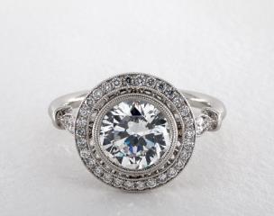 A truly awe-inspiring setting guaranteed to impress, this vintage inspired design offers a bezel with two rows of milgrain inside a pavé halo accented by additional milgrain. The top of the shank continues to excite with pavé and bar accents. Even the underside of the halo features a simple marquise and bar design to allow symmetry throughout the ring.