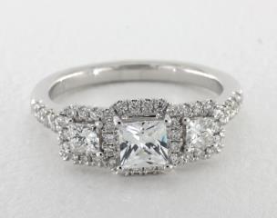 Martin Flyer

The timeless appeal of a three stone diamond engagement by Martin Flyer features two princess shape diamonds (.29 ctw) accentuating the center diamond of your choice.  A brilliant pavé halo surrounds all three diamonds creating a magnificent, larger than life, display of sparkle and fire.  A Flyer Fit exclusive design that is crafted to allow the engagement ring and wedding band to fit perfectly flush with a variety of wedding bands.